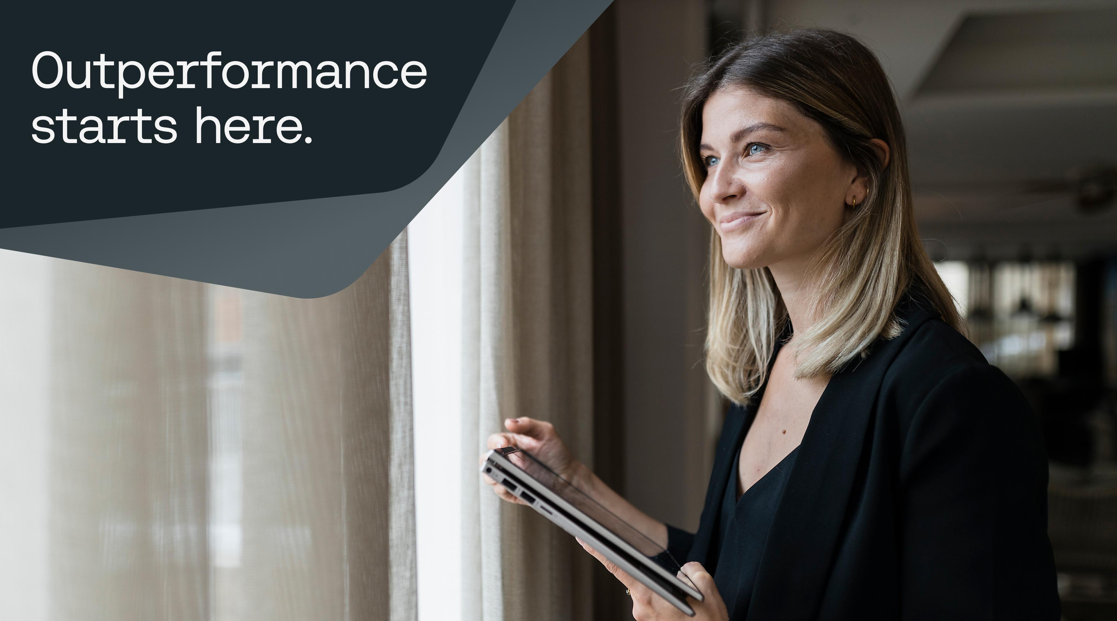 Woman smiling out window with cash forecasting tablet