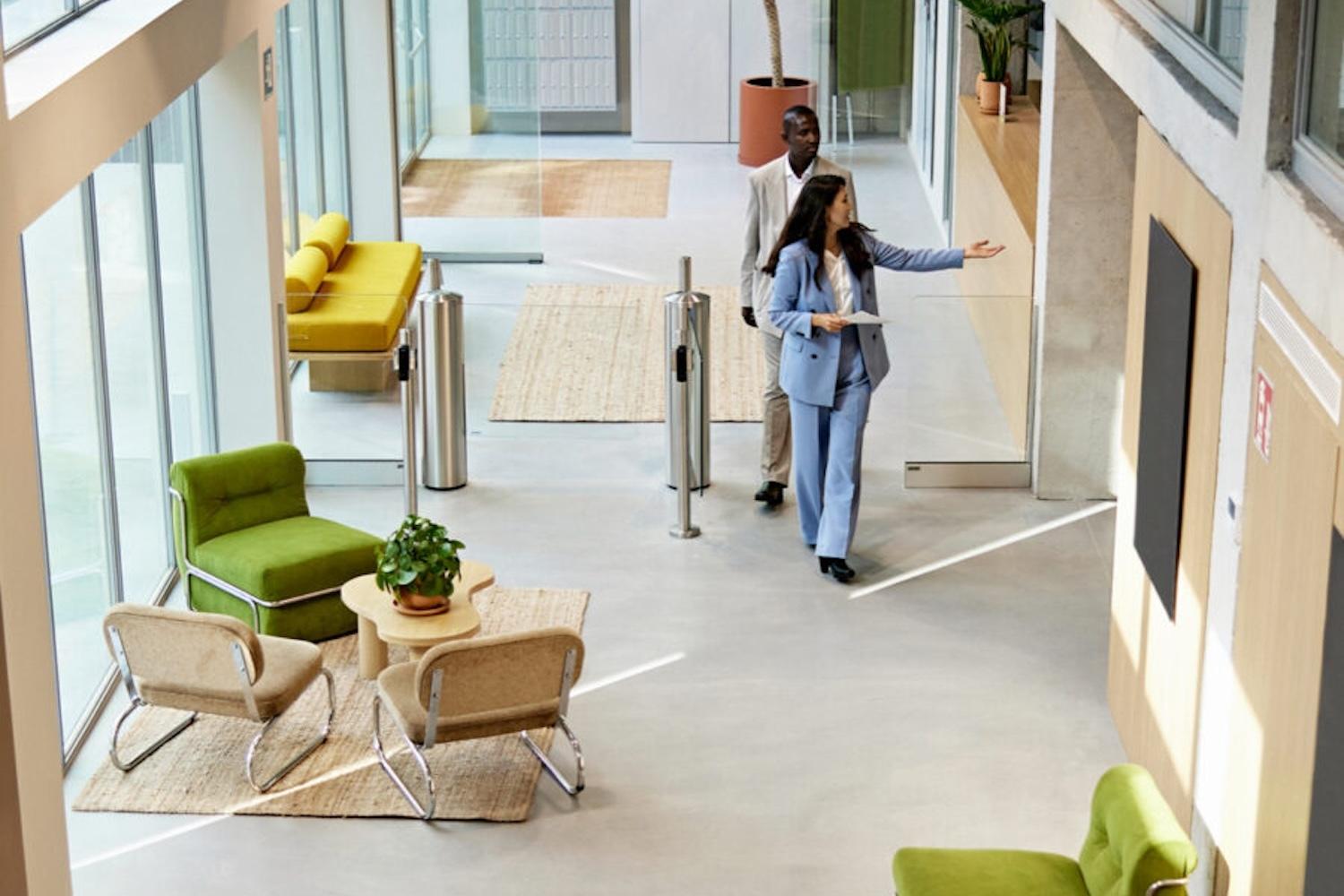 Two individuals walking through a real estate showing of a modern office building